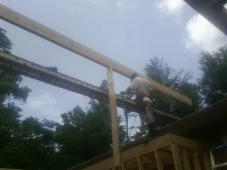 Carpenter setting a ridge beam over a new addition frame — Ice Dam Removal by Roofing Brothers in Zieglerville