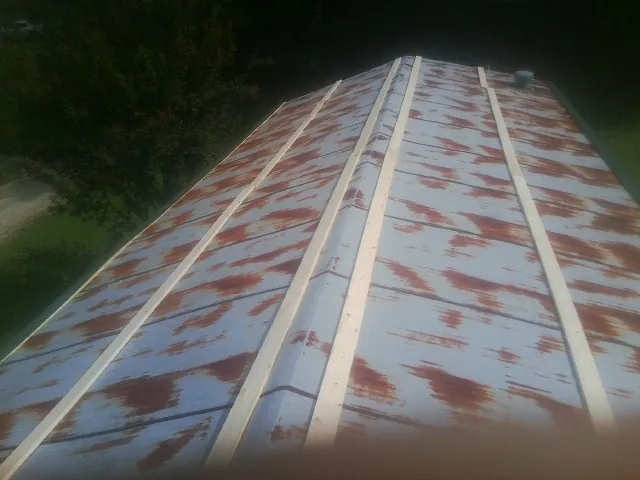 Rusted metal roof panels with new wood purlins before replacement — Storm Damage Roof Repair in Zieglerville by Roofing Brothers