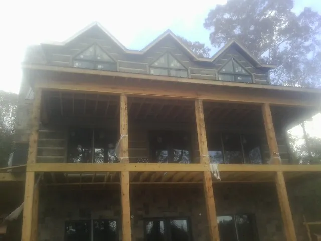 Dormers and porch framing on a large log home under construction — Roof Coating work by our crew in Zieglerville