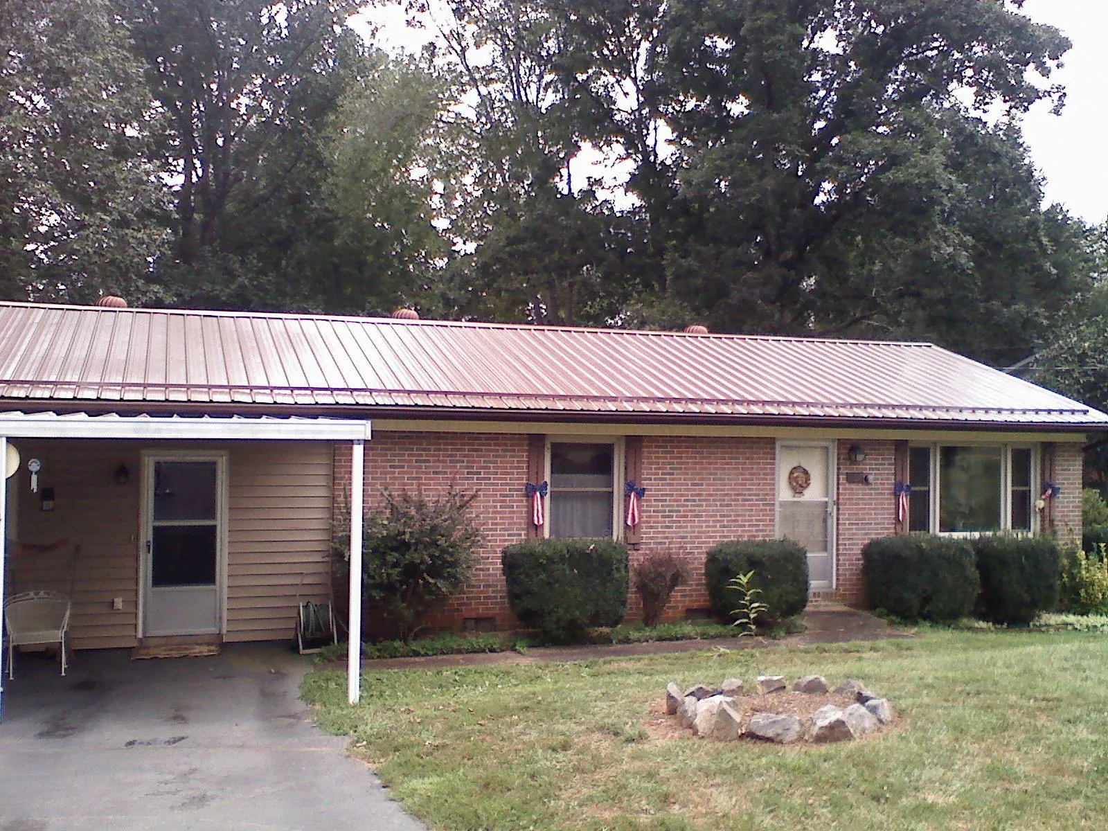 Bronze metal roof and carport on a brick ranch home — Roof Repair work by our crew in Zieglerville